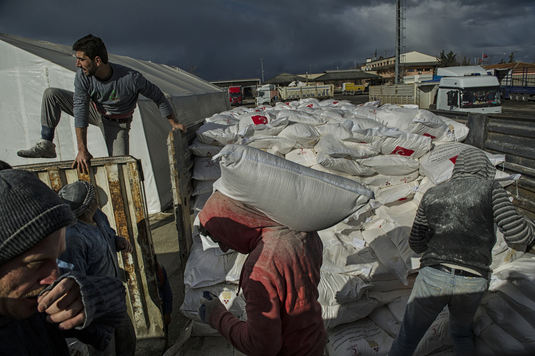 Tonnes of flour are loaded into trucks to be delivered to Syrian refugees