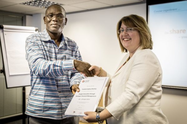 A man accepting a certificate from a woman at a training event.